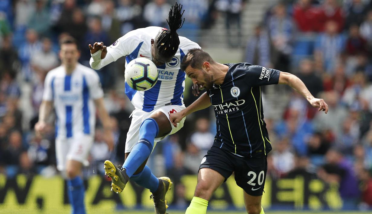 Gelandang Manchester City, Bernardo Silva, berebut bola dengan pemain Brighton and Hove Albion, Yves Bissouma, pada laga Premier League di Stadion AMEX, Minggu (12/5). Manchester City menang 4-1 atas Brighton and Hove Albion. (AP/Frank Augstein)