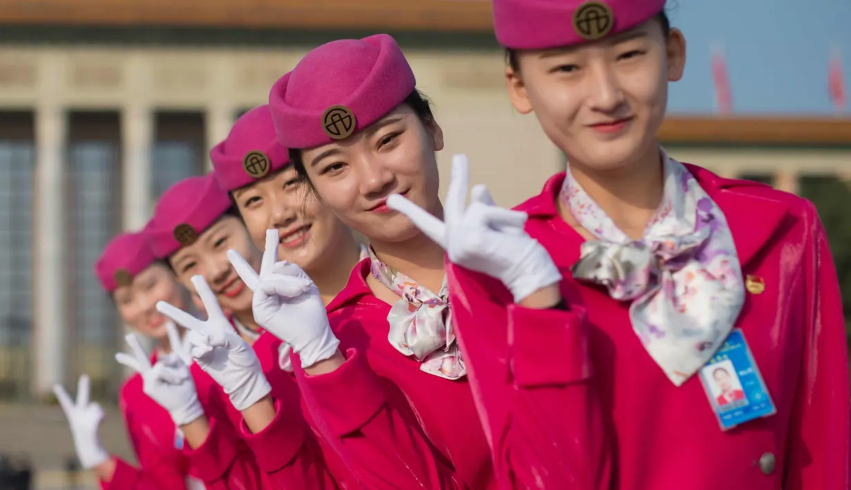 Para pemandu berpose  di lapangan Tiananmen selama sesi penutupan Kongres Partai Komunis ke-19 di Beijing (24/10). Sejumlah wanita cantik ini ditugaskan untuk memandu para peserta kongres. (AFP Photo/ Nicolas Asfouri)