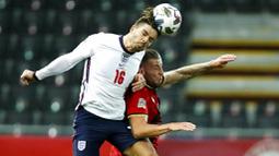 Pemain Inggris, Jack Grealish, duel udara dengan pemain  Belgia, Toby Alderweireld, pada laga UEFA Nations League di Stadion King Power, Senin (16/11/2020). Belgia menang dengan skor 2-0. (AP/Francisco Seco)