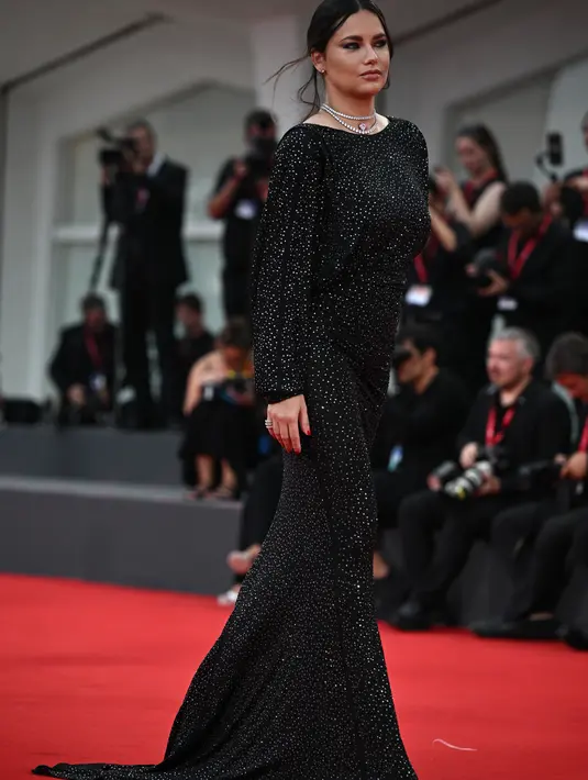Adriana Lima memamerkan baby bump yang semakin membesar dalam balutan gaun glamor saat ia berjalan di karpet merah The Killer di Festival Film Venesia ke-80 di Italia. (Photo by Tiziana FABI / AFP)
