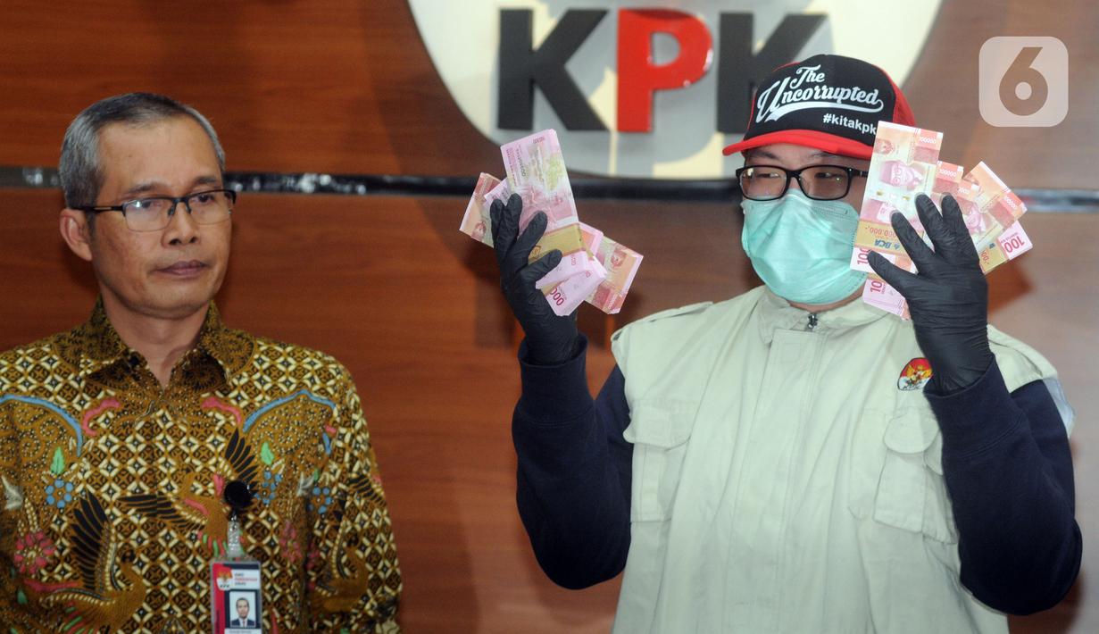 Wakil Ketua KPK, Alexander Marwata (kiri) bersama penyidik menunjukkan barang bukti uang hasil operasi tangkap tangan (OTT) di Sidoarjo di Gedung KPK, Jakarta, Rabu (8/1/2020). Dalam konpers tersebut, KPK menyampaikan hasil OTT yang menetapkan enam tersangka kasus suap. (merdeka.com/Dwi Narwoko)