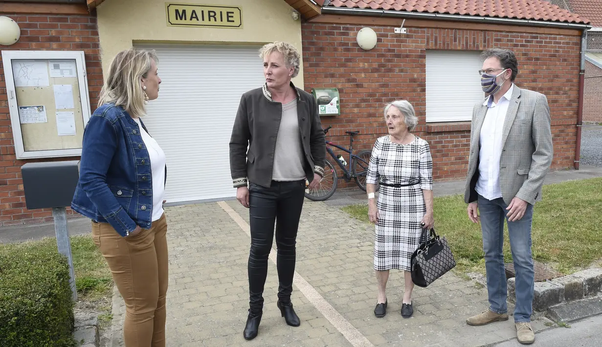 Marie Cau, transgender pertama yang terpilih sebagai wali kota di Prancis berbicara dengan pasangannya Nathalie Lecomte (kiri) dan penasihat kota Dany Fardel (kanan) di depan balai kota Tilloy-lez-Marchiennes pada 24 Mei 2020. (FRANCOIS LO PRESTI/AFP)