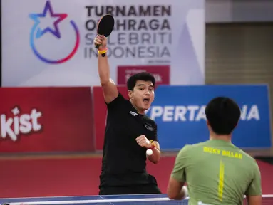 Selebritas Aldi Taher berusaha mengembalikan bola ke arah Rizky Billar saat laga tenis meja Turnamen Olahraga Selebriti Indonesia (TOSI) di GOR UNJ, Jakarta, Minggu (16/07/2023). Aldi Taher kalah tiga set langsung dari Rizky Billar dengan skor 12-21, 15-21, 11-21. (Bola.com/Bagaskara Lazuardi)