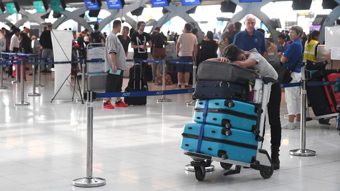 Penumpang beristirahat di area check-in di Bandara Internasional Suvarnabhumi di Bangkok (28/2). Hampir Ribuan penumpang tujuan Pakistan dan Eropa terjebak di bandara tersebut. (AFP Photo/Lillian Suwnrumpha)