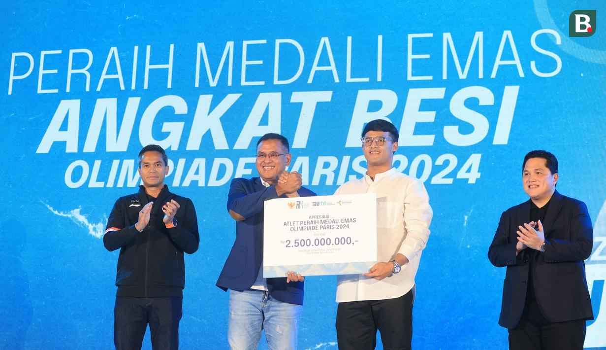 Atlet sekaligus peraih medali emas angkat besi Olimpiade Paris 2024, Rizki Juniansyah (kedua kanan) menerima penghargaan senilai Rp2,5 Miliar dalam acara apresiasi kepada atlet peraih medali Olimpiade 2024 di Pos Bloc, Jakarta, Senin (2/9/2024). (Bola.com/M. Iqbal Ichsan)