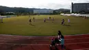 Pengungsi Afghanistan bermain sepak bola di taman bermain Institut Pengembangan Sumber Daya Manusia Nasional di Jincheon, Korea Selatan (13/10/2021). Para pengungsi muncul di hadapan publik pada hari Rabu, untuk pertama kalinya sejak mereka tiba pada akhir Agustus. (AFP/Pool/Jeon Heon-kyun)