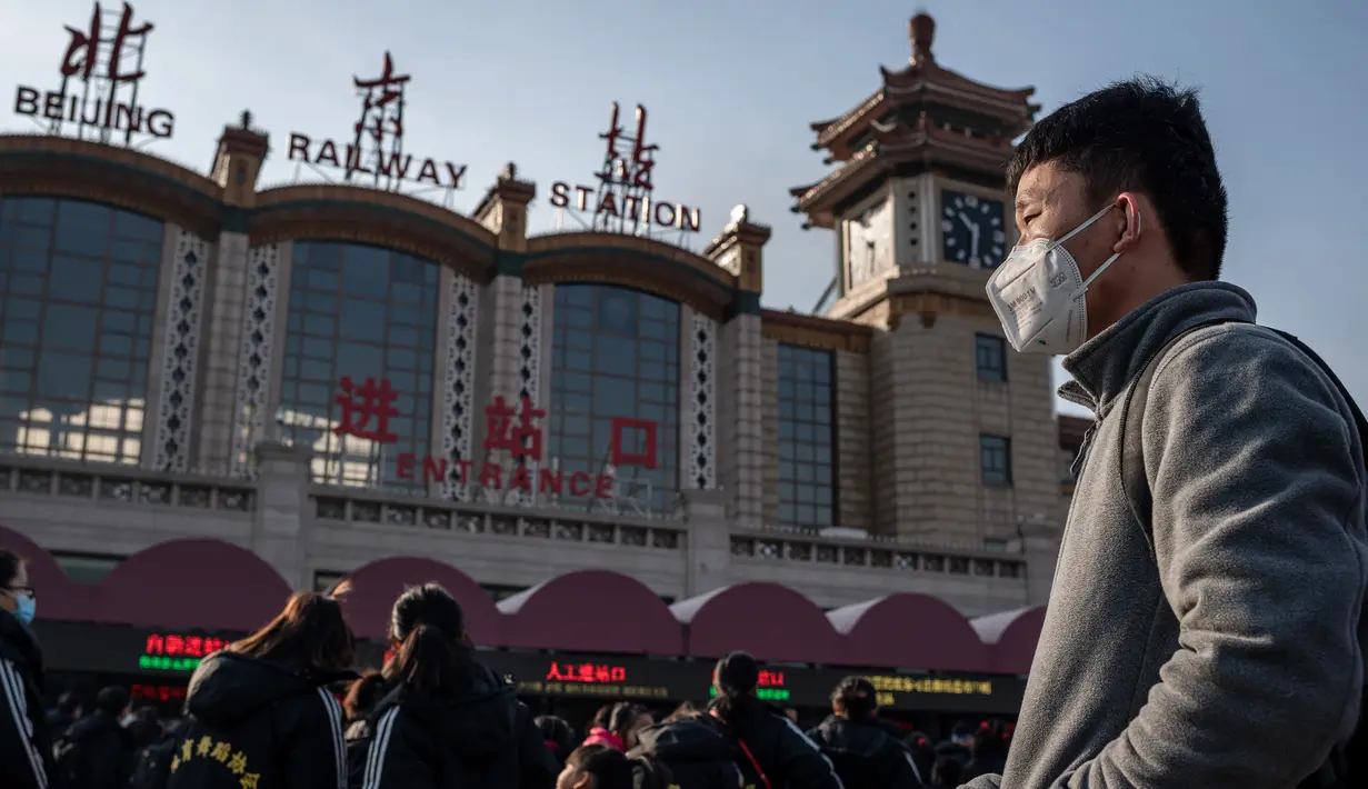 Orang-orang mengenakan masker penutup mulut saat menuju stasiun kereta api Beijing untuk mudik Tahun Baru Imlek pada Selasa (21/1/2020). Virus mirip SARS yang menyebar ke seluruh wilayah China dan mencapai tiga negara Asia ternyata dapat menular dari satu orang ke orang lain. (NICOLAS ASFOURI/AFP)