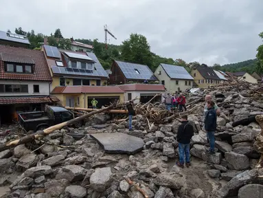 Warga saat memeriksa lokasi tempat tinggal mereka pasca luapan banjir di wilayah Braunsbach, Jerman selatan (30/5). Banjir membawa beragam material lumpur bercampur batu serta ranting hingga batang pohon. (Marijan Murat / dpa / AFP)