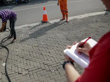 Petugas melakukan pengujian asap saat uji emisi kendaraan bermotor di kawasan Tugu Proklamasi, Jakarta, Selasa (16/5). Suku Dinas Lingkungan Hidup Jakarta Pusat menggelar uji emisi guna menekan angka polusi kendaraan. (Liputan6.com/Faizal Fanani)