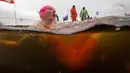 Ekspresi peserta saat mengikuti kompetisi renang di air es dari sungai Neva selama Big Neva Cup of Ice Swimming di St.Petersburg, Rusia, 2 Maret 2019. Sekitar 150 dari 12 negara ambil bagian kompetisi renang dengan suhu - 6 Celcius. (AP/Dmitri Lovetsky)