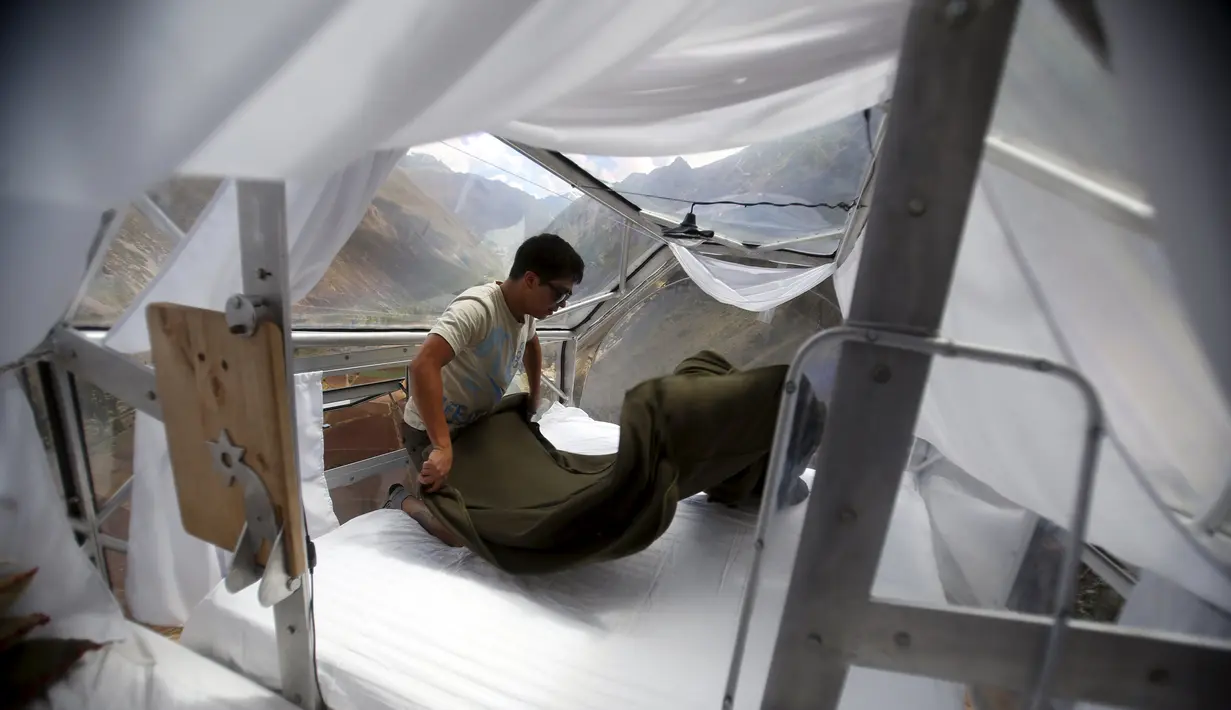 Seorang pemandu resort merapikan kapsul tidur di Skylodge Adventure Suites di Lembah Suci di Cuzco, Peru, 14 Agustus 2015. Hotel yang tergantung dengan ketinggian 400 meter ini memiliki tarif sekitar Rp 4 juta per malam. (REUTERS/Pilar Olivares)