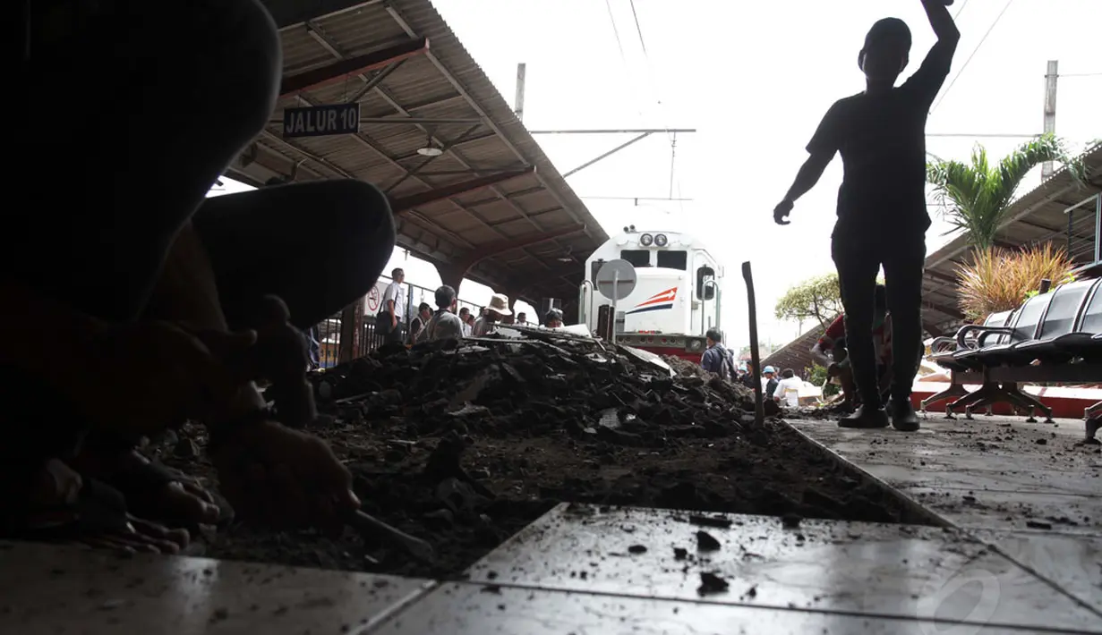 Sejumlah pekerja PT KAI melakukan perbaikan lantai ruang tunggu penumpang di Stasiun Kota, Jakarta yang rusak dihantam lokomotif pada Jumat (26/12/2014). (Liputan6.com/Faizal Fanani)