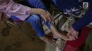 Warga sedang diperiksa kulit bagian kaki di komplek Rusunawa Muara Baru, Jakarta, Selasa (14/5/2019). Pemeriksaan kulit secara cuma-cuma merupakan program Vaseline Healing Project yang bertujuan meningkatkan perilaku hidup bersih dan sehat. (Liputan6.com/Fery Pradolo)