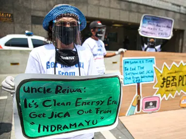 Sejumlah warga dari Indramayu membawa poster saat menggelar aksi di depan Kedubes Jepang, Jakarta, Rabu (21/10/2020). Dalam aksinya, mereka menolak pembangunan PLTU 2 di Indramayu karena akan menyebabkan pencemaran udara dan rusaknya lahan pertanian. (Liputan6.com/Faizal Fanani)