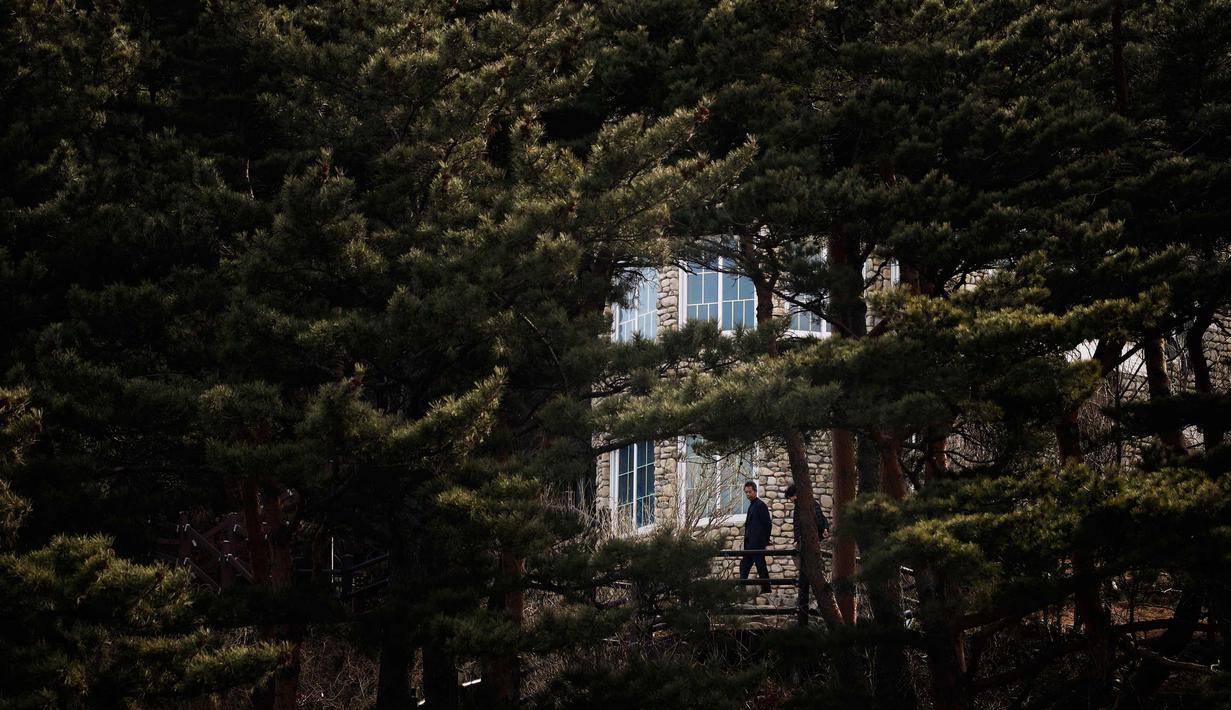 Pengunjung berdiri di luar vila yang dikenal sebagai Kastil Hwajinpodi di Pantai Hwajinpo, Korea Selatan, (19/2). Villa ini merupakan tempat liburan mendiang pendiri Korea Utara Kim Il Sung. (AP Photo/Jae C. Hong)