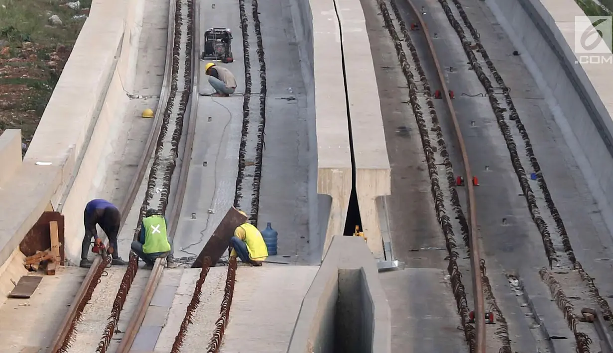 Pekerja memasang besi untuk rel proyek Light Rail Transit (LRT) Jabodebek di Jakarta, Minggu (12/8). Proyek LRT Jabodetabek ditargetkan rampung pada 2019. (Liputan6.com/Immanuel Antonius)