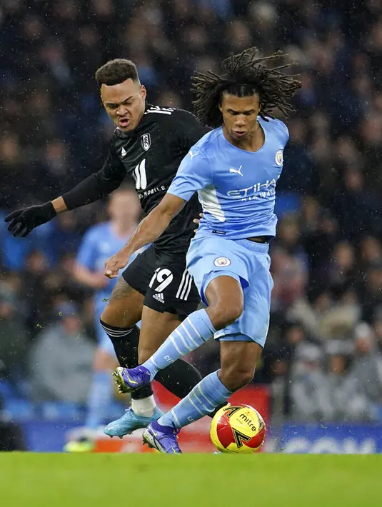 Pemain Fulham Rodrigo Muniz (kiri) berebut bola dengan pemain Manchester City Nathan Ake pada pertandingan sepak bola putaran keempat Piala FA di Etihad Stadium, Manchester, Inggris, 5 Februari 2022. Manchester City menang 4-1. (AP Photo/Jon Super)