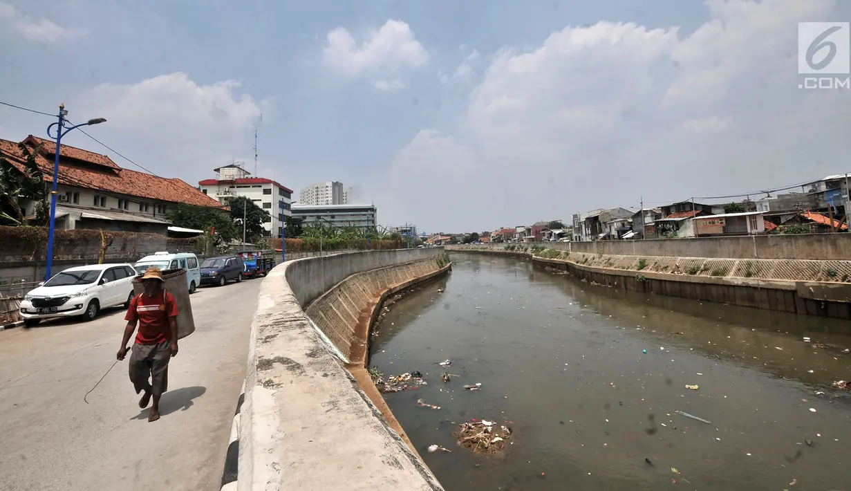 Pemulung melintasi pinggir Kali Ciliwung yang tengah dipenuhi sampah, Jakarta, Selasa (4/9). Kementerian Lingkungan Hidup dan Kehutanan mencatat sekitar 7.000 ton sampah dibuang ke Kali Ciliwung setiap harinya. (Merdeka.com/Iqbal Nugroho)