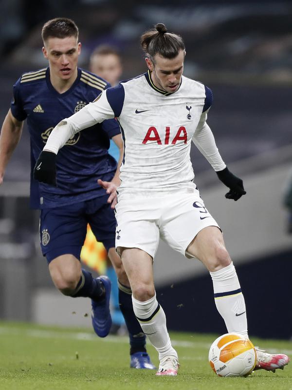 Striker Tottenham Hotspur, Gareth Bale membawa bola dari kawalan pemain Dinamo Zagreb, Rasmus Lauritsen pada leg pertama babak 16 besar Liga Europa di ottenham Hotspur Stadium, Inggris, Jumat (12/3/2021). Tottenham unggul dua gol dan menorehkan clean sheet di kandang. (AP Photo/Alastair Grant, Pool)