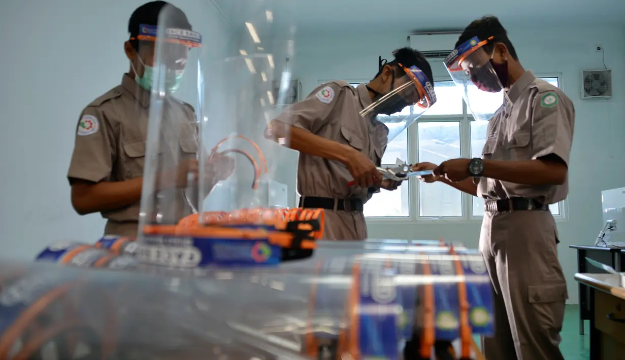 Siswa Sekolah Menengah Kejuruan memproduksi alat pelindung wajah (face shield) di Banda Aceh, Aceh, Jumat (12/6/2020). Selain memproduksi alat pelindung wajah, mereka juga membuat hand sanitizer yang akan disumbangkan untuk tenaga medis penanganan COVID-19. (CHAIDEER MAHYUDDIN/AFP)