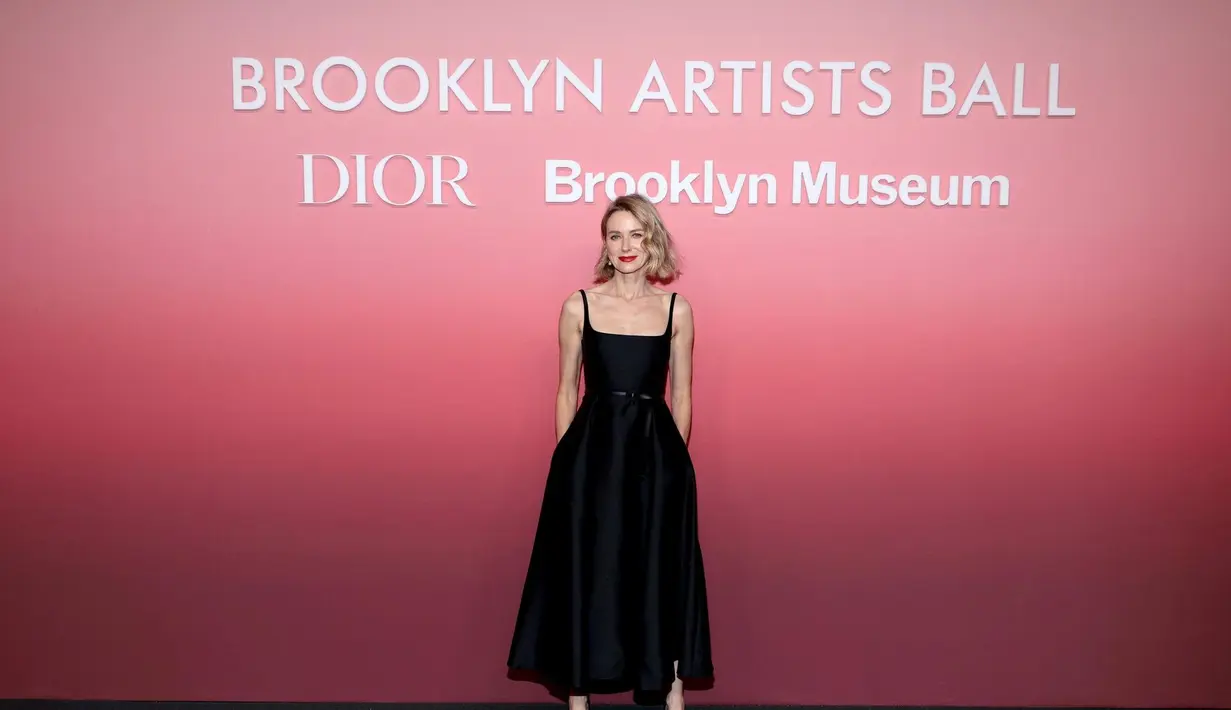 Naomi Watts mengenakan gaun dan ikat pinggang wol hitam dan sutra Dior. Dia juga mengenakan tas dan sepatu Dior. [Dior]