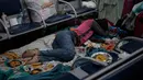 Imigran Kolombia yang telantar tidur di Bandara Internasional Guarulhos, di Guarulhos, dekat Sao Paulo, Selasa (26/5/2020). Ratusan orang yang menunggu bantuan untuk kembali ke negara mereka itu hidup dari sumbangan, tidur di lantai dan bangku serta mandi di toilet bandara. (Miguel SCHINCARIOL/AFP)