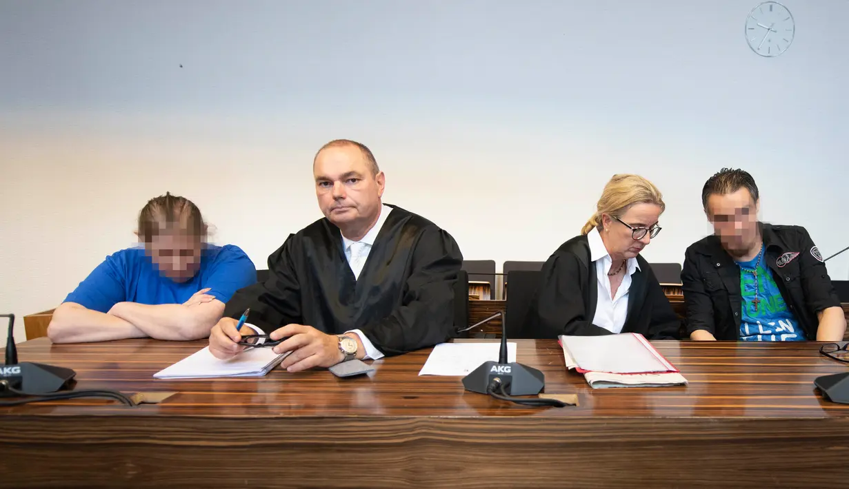 Terdakwa Berrin T (kiri) dan Christian L (kanan) bersama pengacara menunggu sidang putusan di pengadilan distrik di Freiburg, Jerman, Selasa (7/8). Berrin dan Christian diadili karena mencabuli dan menjual putranya ke situs paedofil. (THOMAS KIENZLE/AFP)