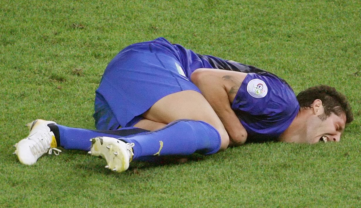 Bek Italia, Marco Materazzi, terkapar usai ditanduk oleh gelandang Prancis, Zinedine Zidane saat final Piala Dunia 2006 Stadion Olympic, Berlin, Jerman (9/7/2006). Tandukan tersebut merupakan salah satu momen ikonik pada ajang Piala Dunia 2006. (AFP/John Macdougall)