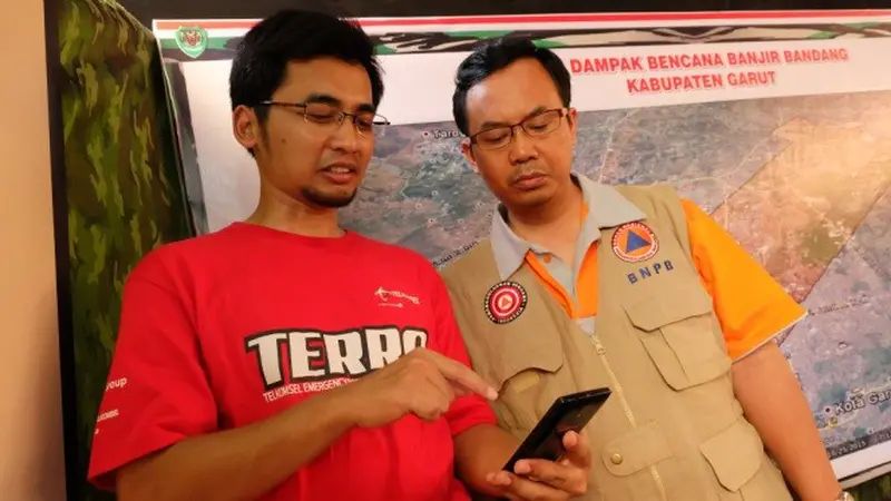 Petugas Lapangan Telkomsel Emergency Response & Recovery Activity (TERRA) sedang menjelaskan kepada petugas Badan Nasional Penanggulangan Bencana (BNPB) mengenai penggunaan beragam fitur yang tersedia dalam aplikasi TERRA 