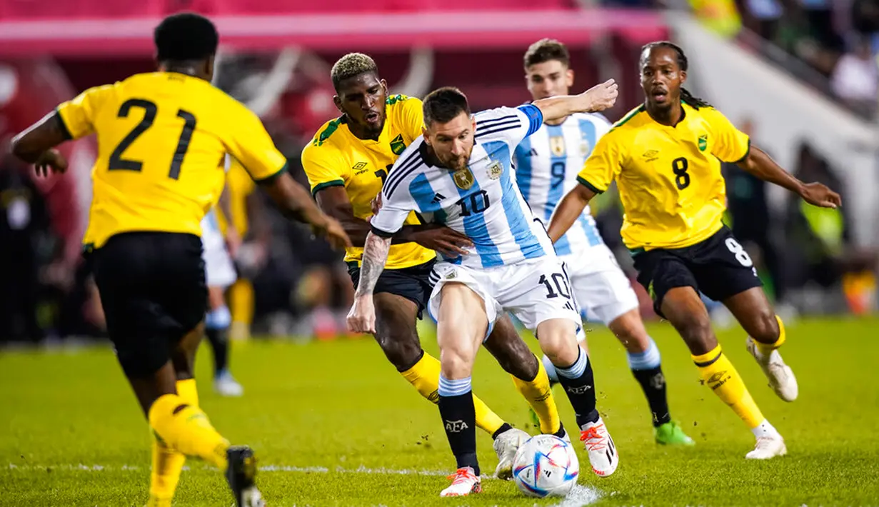 Pemain depan Argentina Lionel Messi (tengah) berebut bola dengan pemain Jamaika Shamar Nicholson pada pertandingan persahabatan di Harrison, New Jersey, Amerika Serikat, 27 September 2022. Argentina menang 3-0 dengan Messi mencetak dua gol. (AP Photo/Eduardo Munoz Alvarez)