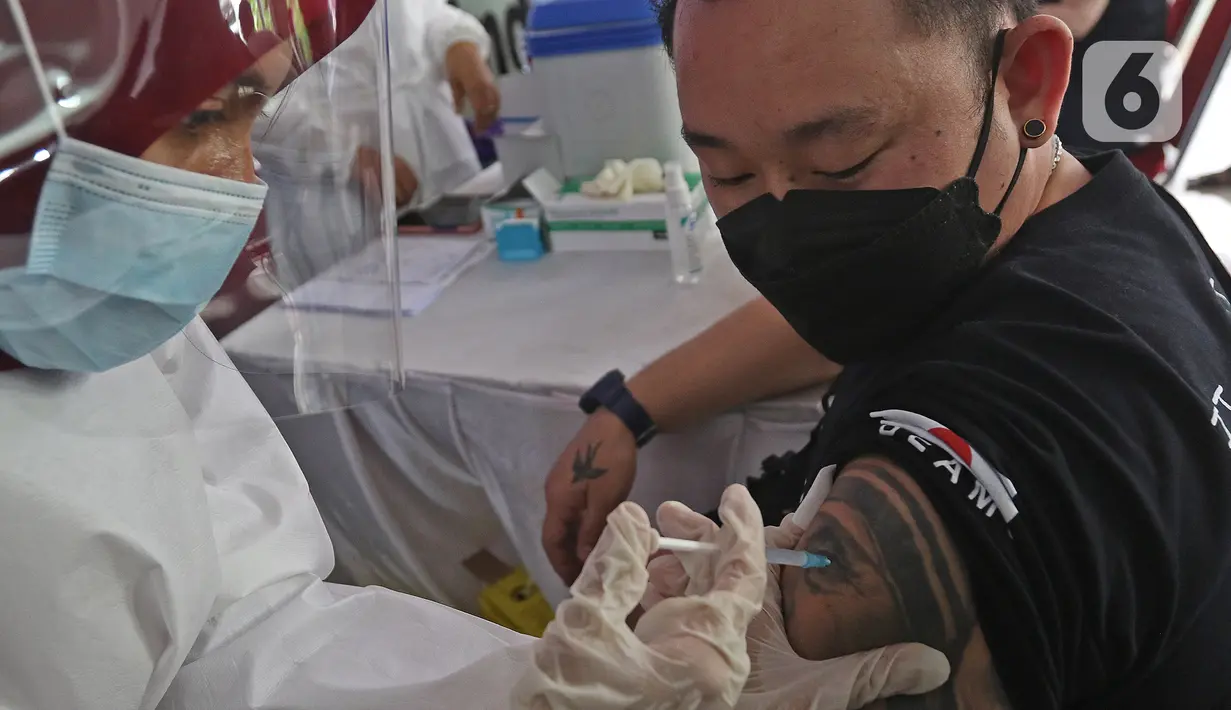 Pedagang menjalani vaksinasi COVID-19 di Pasar Tanah Abang Blok A, Jakarta, Rabu (17/2/2021). Total sasaran vaksinasi tahap kedua ini mencapai 38.513.446 yang terdiri dari 21 juta lebih lansia, dan hampir 17 juta untuk pekerja pelayanan publik. (Liputan6.com/Herman Zakharia)