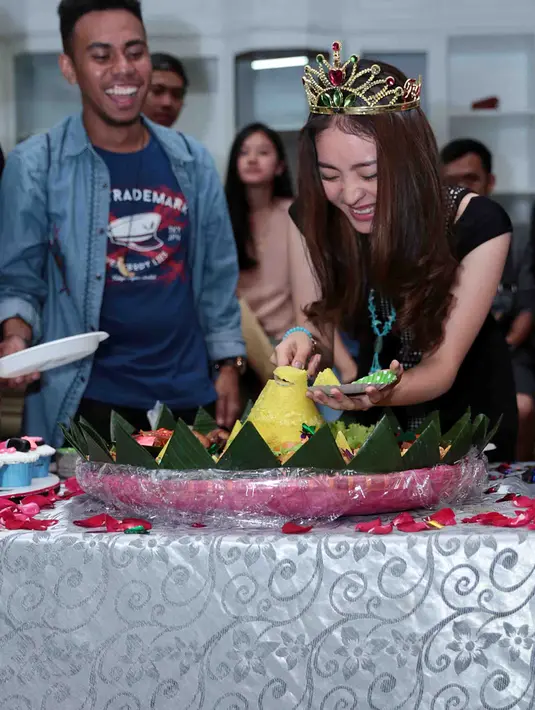 Tidak hanya sekedar potong kue ulang tahun dan tiup lilin, Natasha juga tampak sedang memotong nasi tumpeng kuning sambil tersenyum bahagia. (Deki Prayoga/Bintang.com)