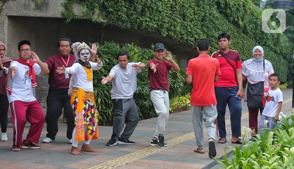 Sejumlah mahasiswa melakukan paduan suara dan gerak tari saat Car Free Day, di Jakarta, Minggu (25/9/2022). Pagelaran ini merupakan bentuk pengenalan seni kepada masyarakat yang tengah melakukan aktivitas di CFD. (Liputan6.com/Angga Yuniar)