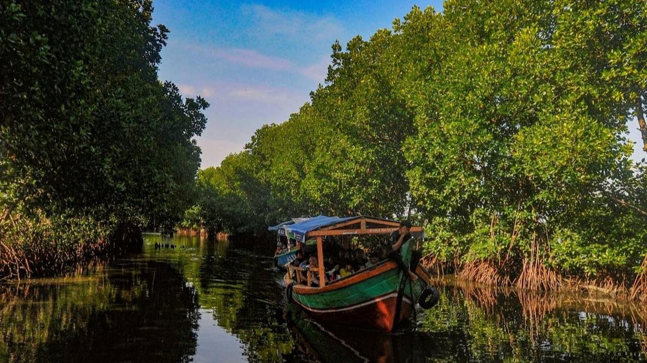 Perahu nelayan yang membawa wisatawan melewati kawasan mangrove di Sunge Jingkem di Kp. Sembilangan, Tarumajaya, Kabupaten Bekasi, Sabtu (13/4/2024). Destinasi ini menawarkan ekosistem mangrove yang indah dan unik untuk wisatawan yang mencari pengalaman a