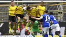 Para pemain Borussia Dortmund berusaha menghadang tendangan pemain Schalke 04, Daniel Caligiuri, pada laga Bundesliga di Stadion Signal Iduna Park, Sabtu (16/5/2020). Dortmund menang 4-0 atas Schalke 04. (AP/Martin Meissner)