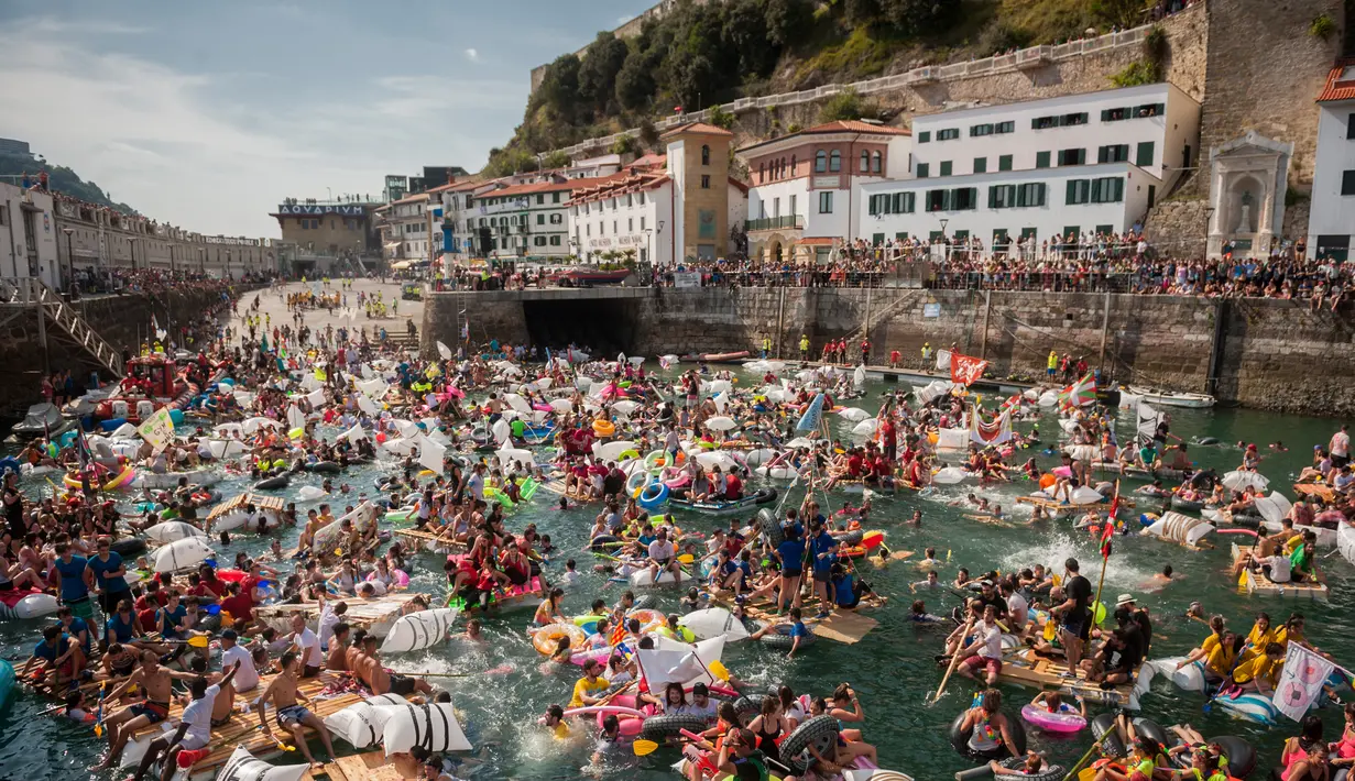 Ribuan orang berdatangan mendayung perahu rakitan buatan mereka di pelabuhan kota Basque San Sebastian utara selama (12/8).  Acara ini menghadirkan Pesta, Konser, Acara berperahu bertema bajak laut Dan kembang api malam. (AFP Photo/Gari Garaialde)