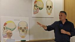 Liran Carmel menjelaskan model cetak 3D wajah gadis spesies manusia prasejarah Denisovan di Universitas Ibrani di Yerusalem (19/9/2019). Wajah gadis yang meninggal 40.000 tahun yang lalu di Siberia ini telah terungkap untuk pertama kalinya. (AFP Photo/Menahem Kahana)