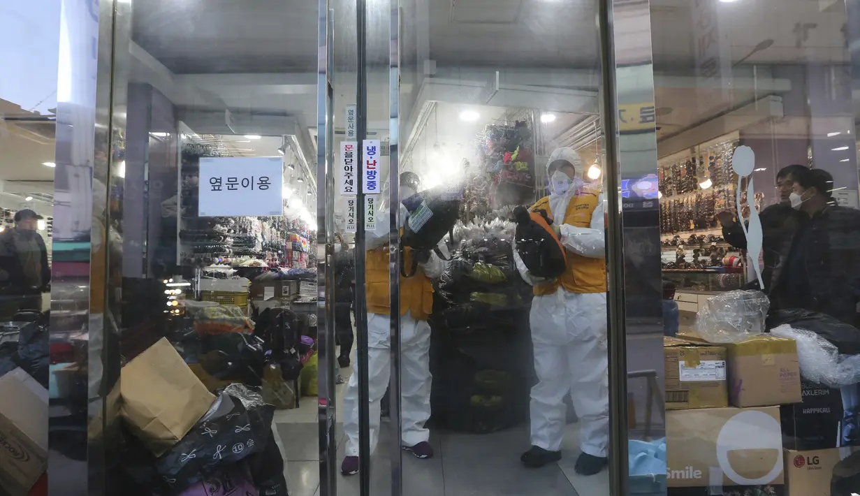Pekerja mengenakan pakaian pelindung menyemprotkan disinfektan sebagai tindakan pencegahan terhadap virus corona baru di Pasar Namdaemun di Seoul, Korea Selatan, Rabu, (5/2/2020). Kematian akibat virus corona naik menjadi 490 di daratan China pada Rabu (5/2). (AP Photo/Ahn Young-joon)