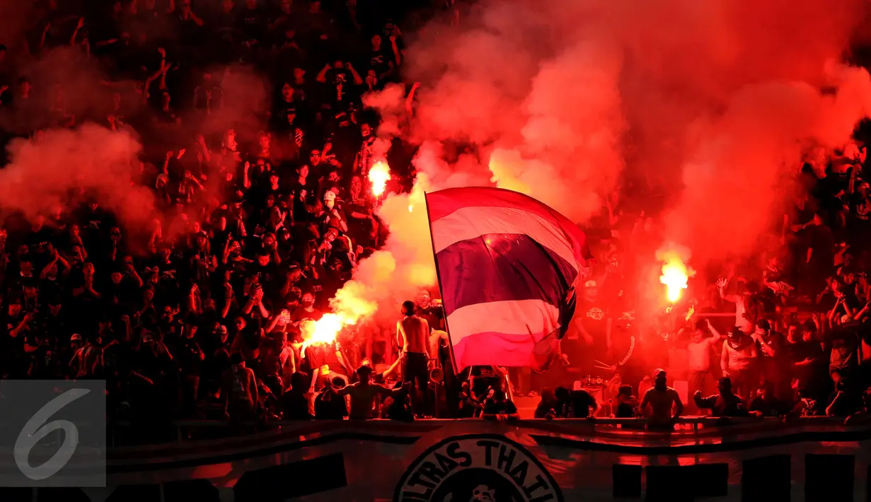 Suporter Timnas Thailand menyalakan suar saat menyambut kemenangan timnya atas Indonesia di National Stadium Rajamangala, Bangkok, Sabtu (17/12). Thailand berhasil meraih piala AFF untuk yang kelima kali. (Liputan6.com/Helmi Fithriansyah)