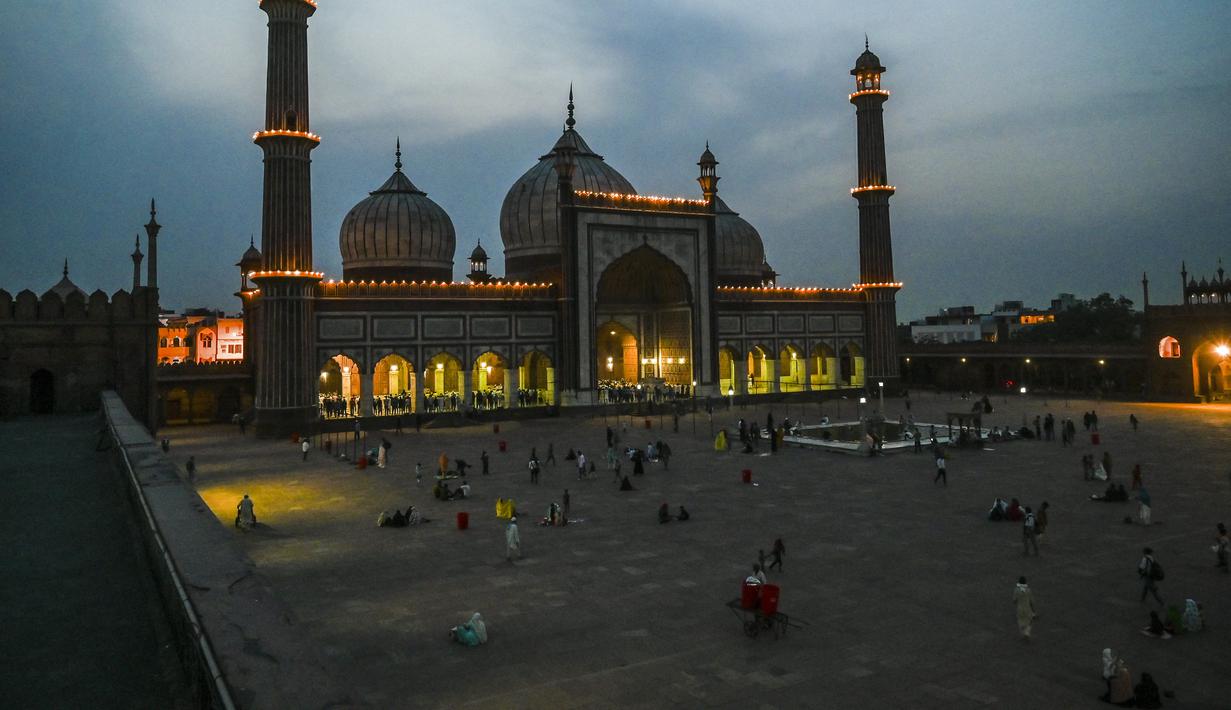 Umat Muslim berbuka puasa di masjid Jama Masjid pada hari pertama bulan suci Ramadhan, di New Delhi (14/4/2021). Masjid ini didirikan oleh Kaisar Mogul, Syah Jehan, yang juga membangun Taj Mahal. (AFP/Prakash Singh)