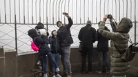 Wisatawan mengunjungi puncak Empire State Building, New York City, AS, Rabu (1/3) Badan Pariwisata NYC & Company mengatakan jumlah wisatawan asing berkurang sekitar 300.000 pengunjung. (Drew Angerer / Getty Images / AFP)