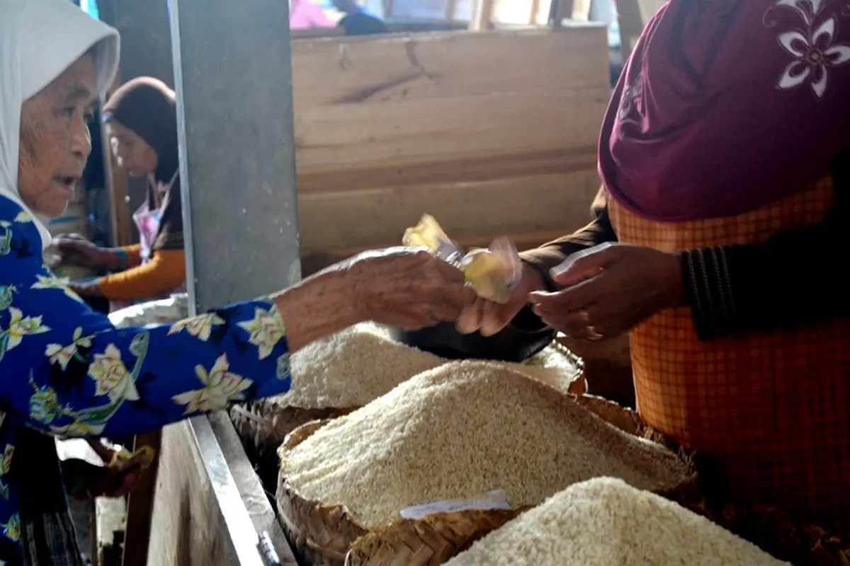 Seorang nenek membayar beras di pasar tradisional Cilacap, Jawa Tengah. (Foto: Liputan6.com/Muhamad Ridlo)