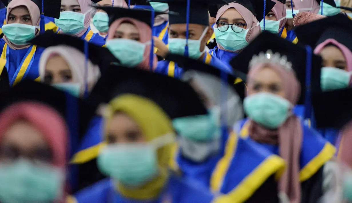 Sejumlah pelajar yang memakai masker sebagai tindakan pencegahan terhadap virus corona COVID-19 mengikuti acara wisuda SMK Farmasi di Banda Aceh (24/9/2020). (AFP/Chaideer Mahyuddin)