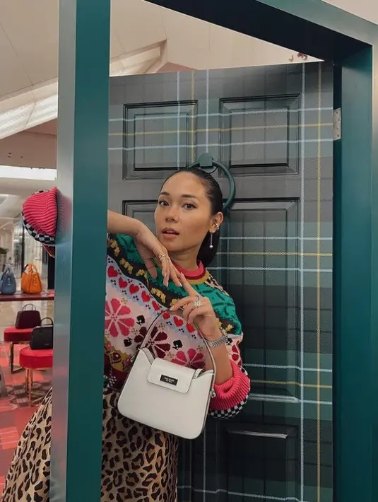 <p>Ayla Dimitri juga tampil colorful kenakan tas Kate Spade New York. Ia memadukan Sam Icon Mini Hobo Bag berwarna putih dengan baju full-pattern dan warna yang playful. Tas ini memiliki detail magnetic tab flap closure dan crossbody strap yang bisa dilepas-pasang. Foto: Instagram.</p>