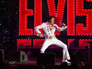 Seorang penyanyi, Jason Dale tampil dalam pembukaan 'Perayaan Elvis 2018' di Blackpool Winter Gardens, Barat Laut Inggris, Jumat (29/6). Festival ini digelar untuk memperingati penyanyi legendaris Elvis Presley. (Oli SCARFF/AFP)