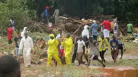 Petugas penyelamat membawa mayat korban dari lokasi tanah longsor di Regent, sebelah timur Freetown, Sierra Leone, (14/8). Bencana ini terjadi saat penduduk tengah tidur sehingga banyak yang terjebak di dalam rumah. (AP Photo / Manika Kamara)