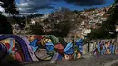 Warna-warni mural menghiasi tembok di permukiman kumuh Petare di Caracas pada 29 Mei 2019. Petare yang merupakan kawasan kumuh terbesar di Venezuela menjadi rumah bagi lebih dari 500.000 jiwa. (Photo by MARVIN RECINOS / AFP)