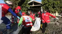 Tim Palang Merah Indonesia (PMI) membawa tubuh korban setelah gempa dan tsunami menghantam Palu, Sulawesi Tengah, Senin (1/10). Sebanyak 18 negara menawarkan bantuan untuk bencana gempa dan tsunami Palu-Donggala. (AP Photo/Tatan Syuflana)