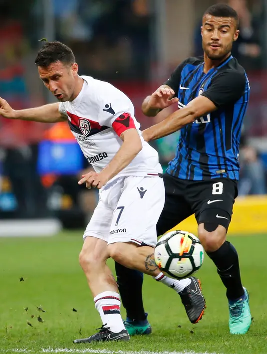Pemain Inter Milan,  Rafinha berebut bola dengan pemain Cagliari, Andrea Cossu pada laga pekan ke-33 Serie A, di Giuseppe Meazza, Selasa (17/4).  Menjamu Cagliari, Inter Milan memetik kemenangan meyakinkan dengan skor 4-0. (AP/Antonio Calanni)