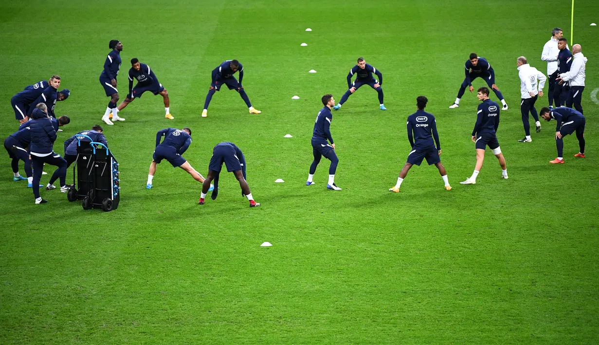Bek Prancis Benjamin Pavard (kanan) bersama rekan-rekannya melakukan pemanasan selama sesi latihan di stadion Stade de France di Saint-Denis, Paris (16/11/2020). Prancis akan menghadapi Swedia pada matchday Grup A3 UEFA Nations League 2020/21 di Stade de France, Saint-Denis, Paris. (AFP/Franck Fife)
